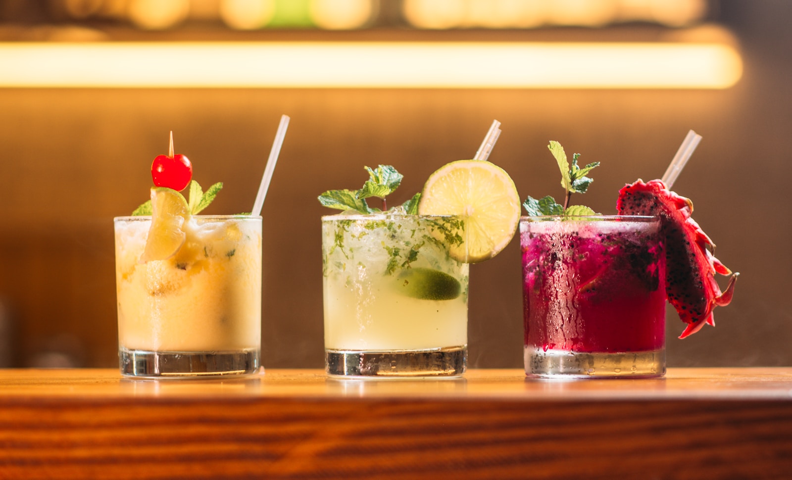 Three garnished drinks on the bar