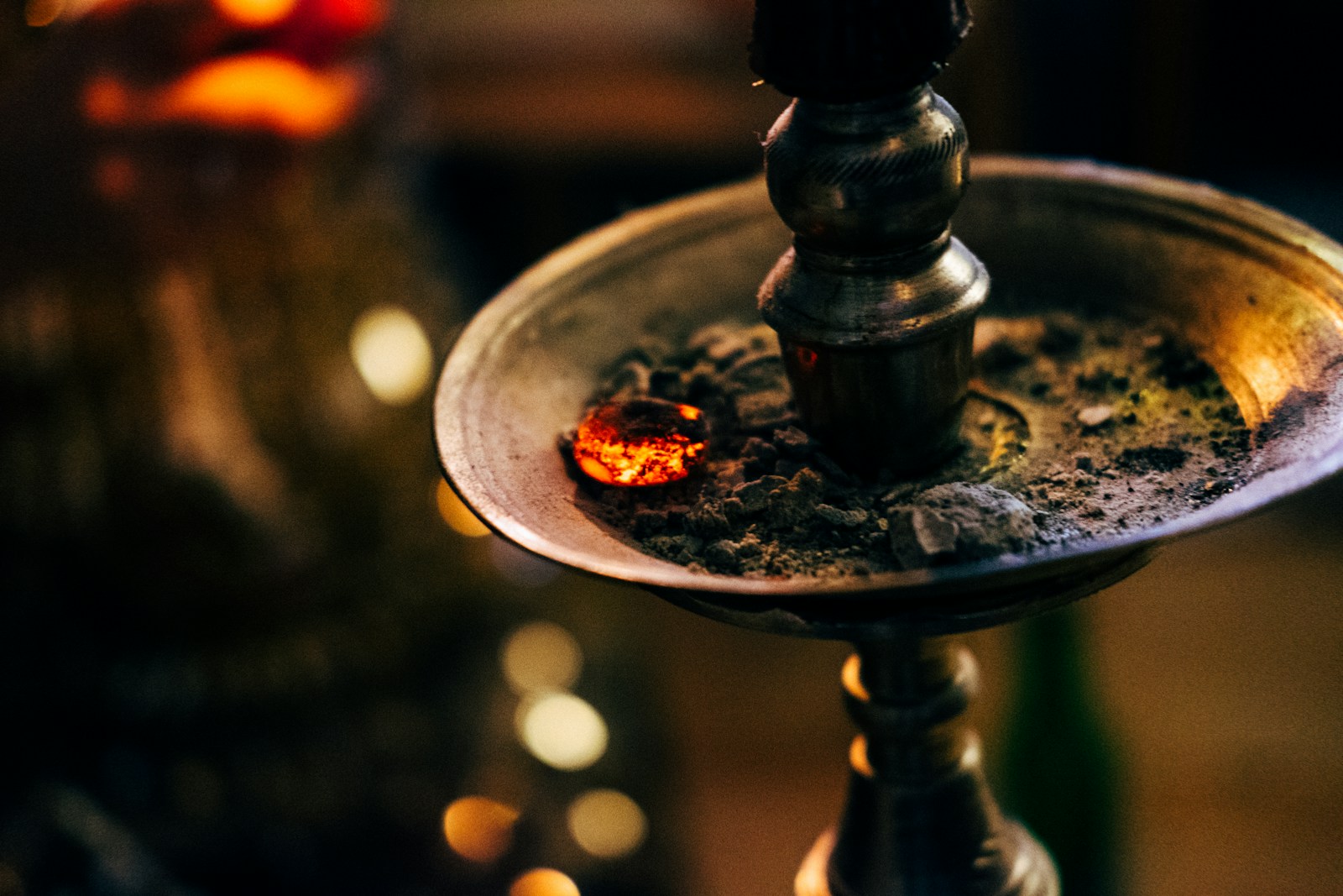 A glowing coal resting on a hookah tray